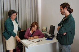 01-anna-amelia A ex-entrevistada do Vale Registrar, Anna Amélia Lopes de Oliveira, assina o Termo de Doação, ao lado da Assessora Técnica e do Gerente Operacional do Núcleo de História Oral, Josanne Simões e Eder Melo, na Sala de Histórias, da Estação Ferroviária de Ouro Preto. Foto: Rafael Santos