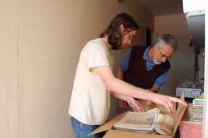 01-emprestimo-de-acervo O pesquisador Eder Melo e o entrevistado do Vale Registrar, Rafael Arcanjo Santos, proprietário do acervo de antigos jornais de Mariana, separam exemplares para o empréstimo. Foto: Wesley Souza